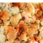 A bowl of vegan potato salad topped with paprika and chives.