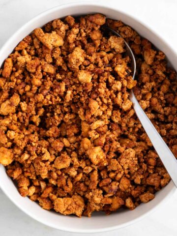 Crumbled tofu ground beef in a bowl with a spoon.