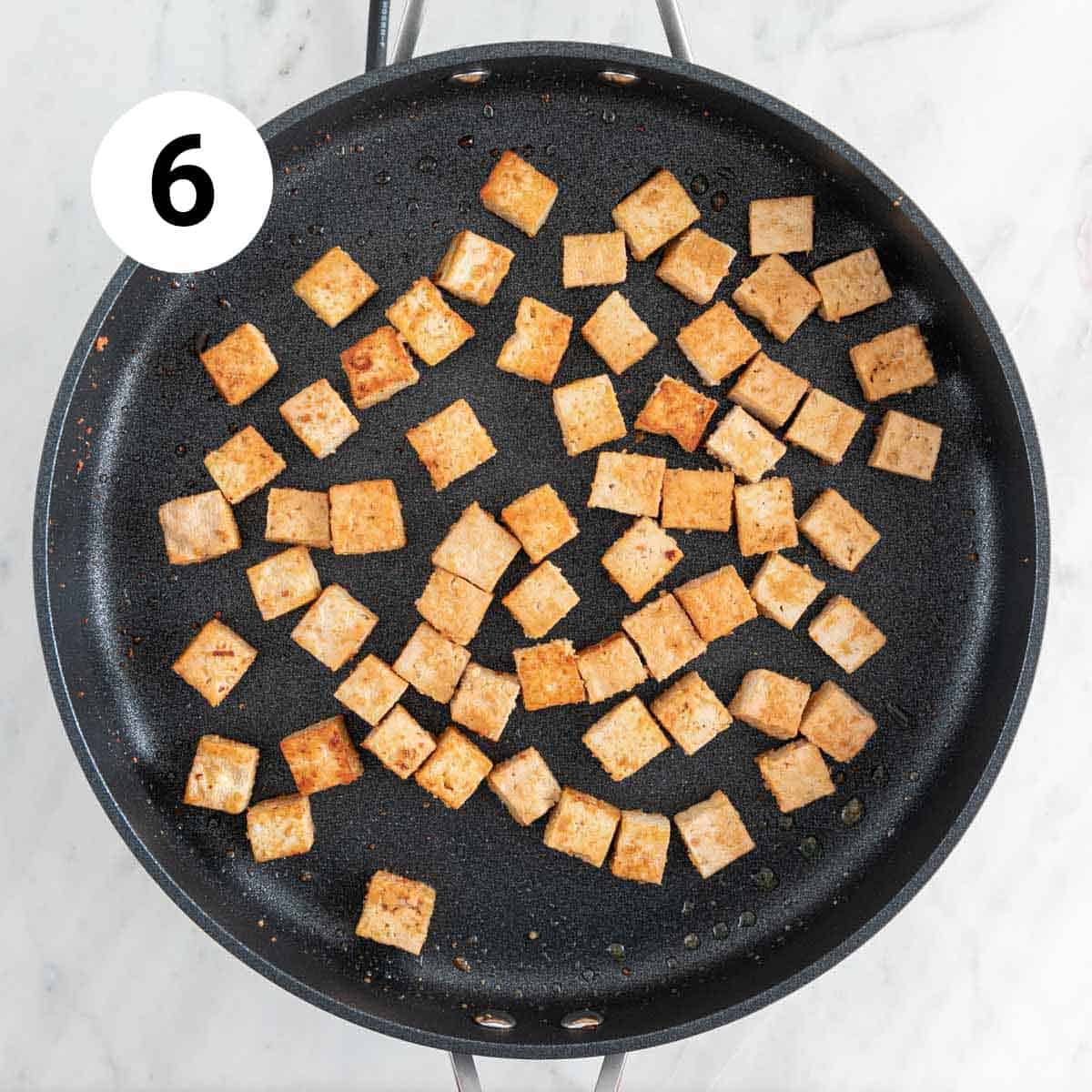 Sautéed tofu cubes in a skillet.