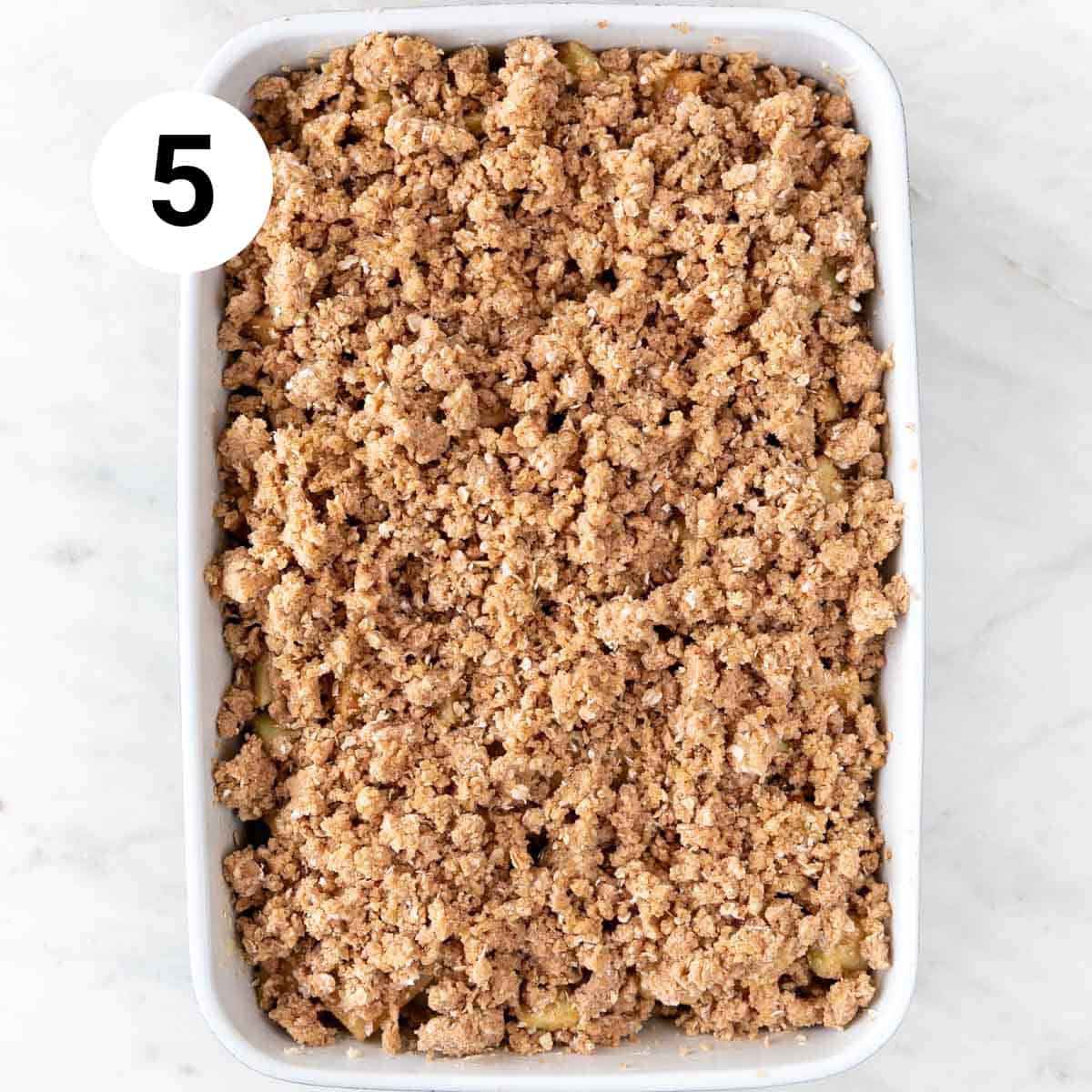 Baking dish with vegan apple crisp before baking.