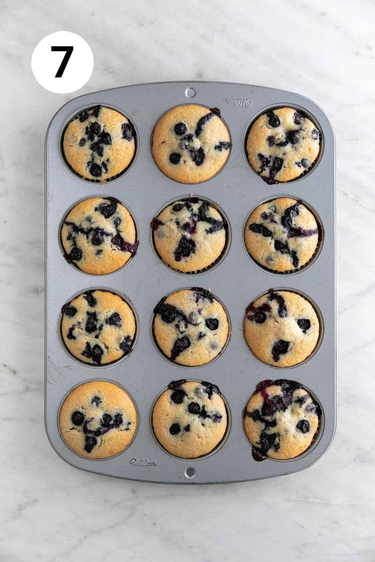 Freshly baked vegan blueberry muffins in a muffin tin.