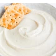Bowl of vegan cashew cheese with crackers.