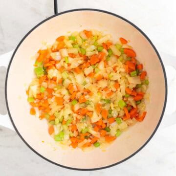 Sautéed vegetables in a large pot.