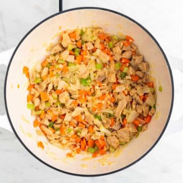 Sautéed vegetables and vegan chicken in a large pot.