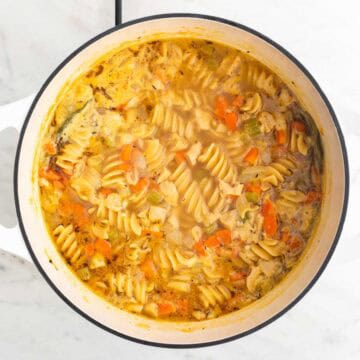Vegan chicken noodle soup in a large pot.