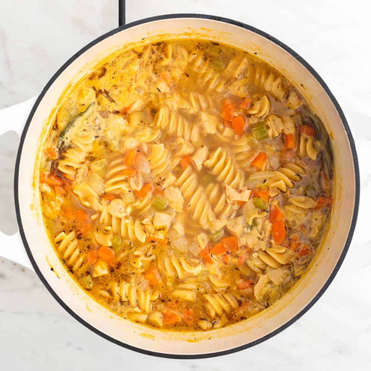 Vegan chicken noodle soup in a large pot.
