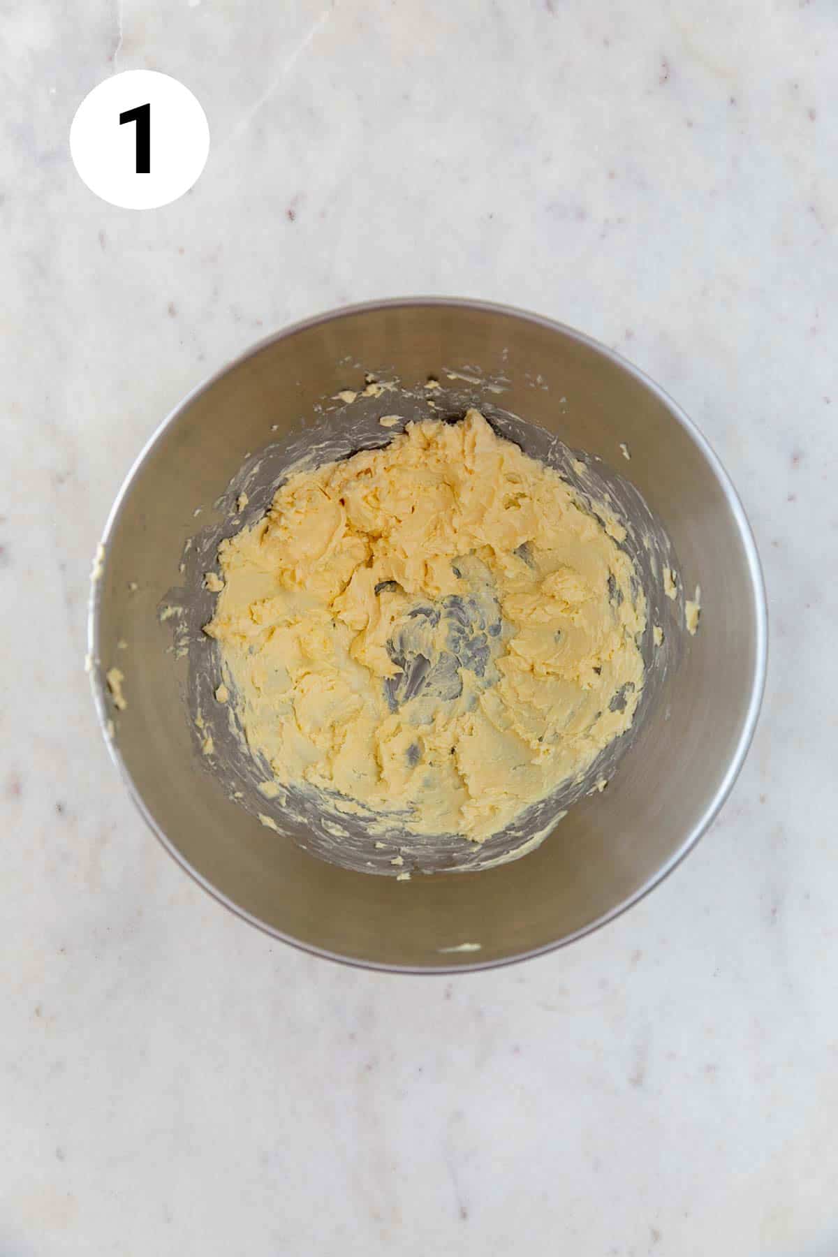 A bowl with fluffy vegan butter after beating in an electric mixer.