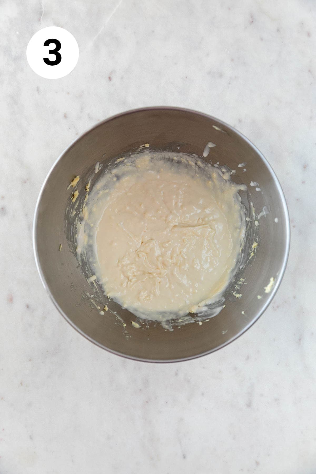 Vegan butter, vegan cream cheese, vanilla extract, and salt beaten in an electric mixer's bowl.