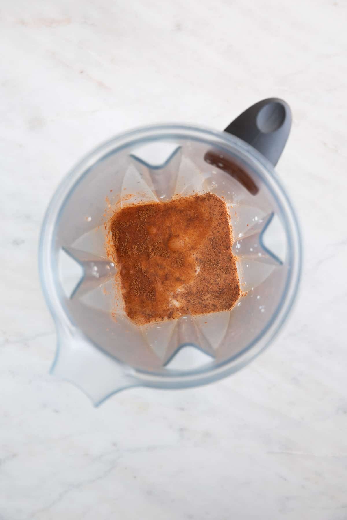 All the vegan eggnog ingredients in a blender before blending.