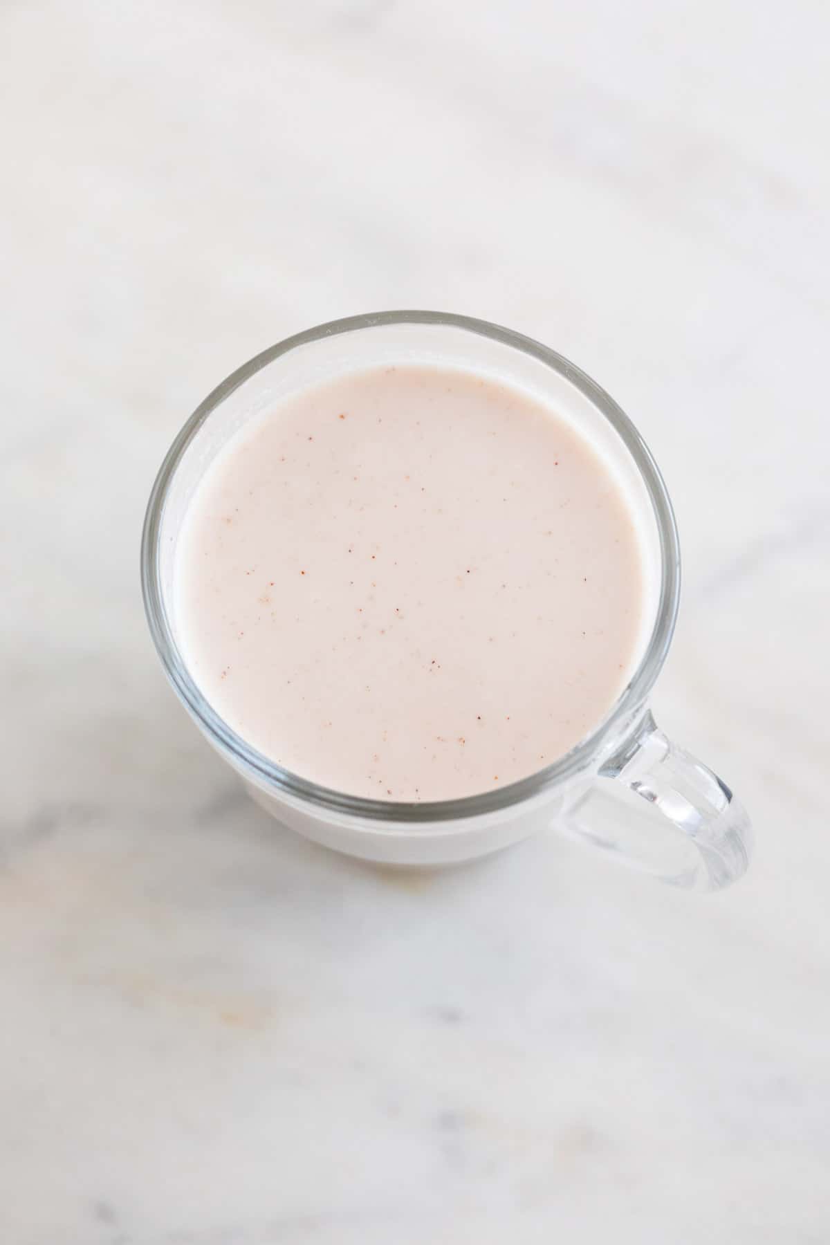 A glass jar of dairy-free eggnog.