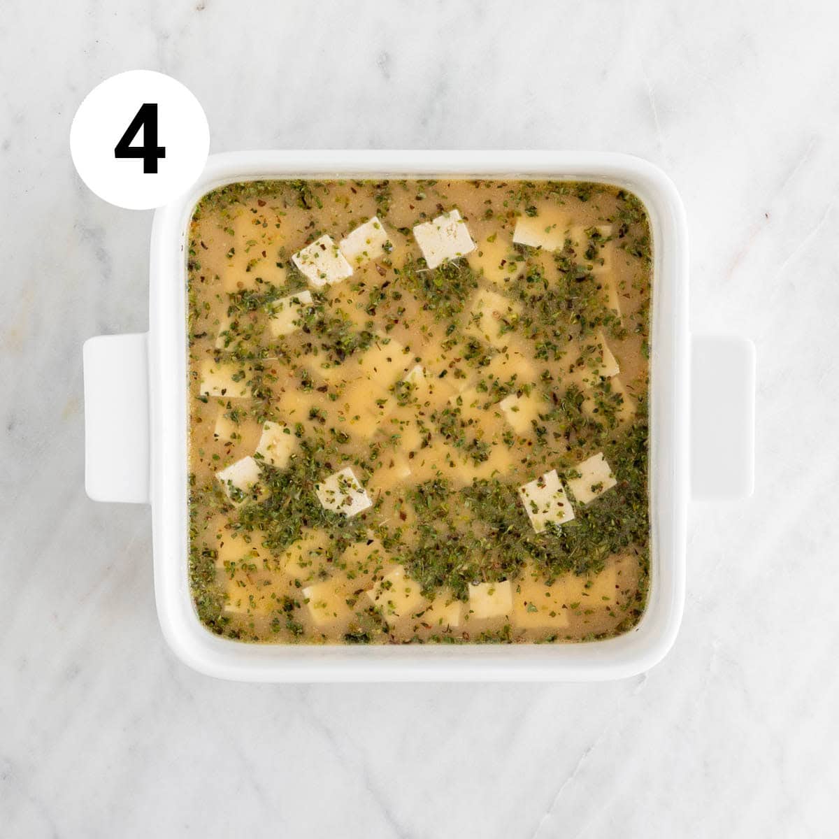 Tofu cubes marinating in baking dish.