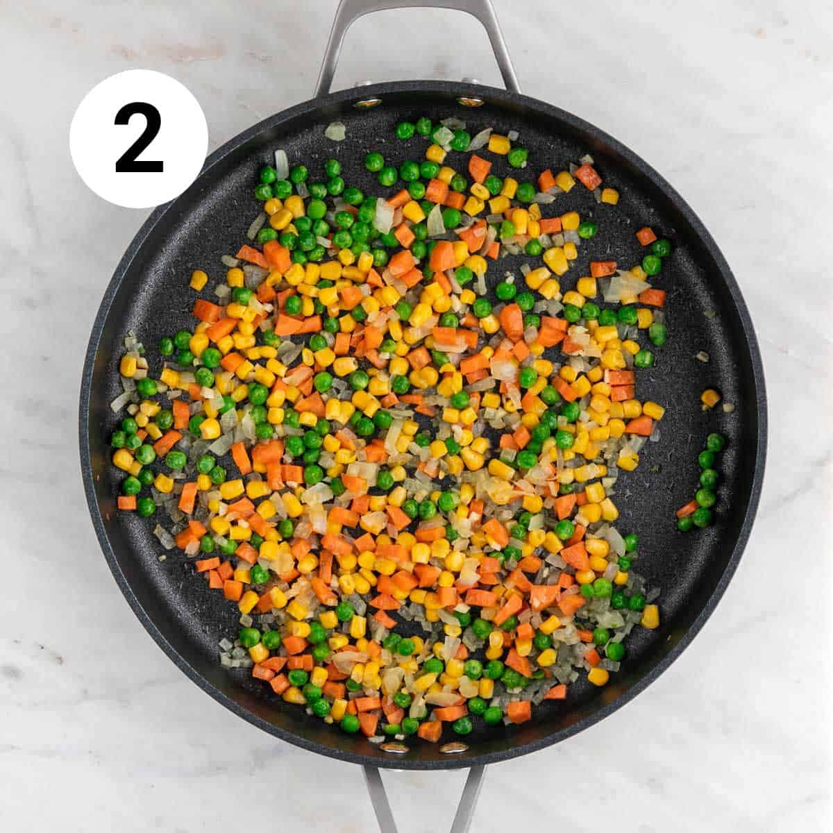 Sautéed veggies in a large pan.