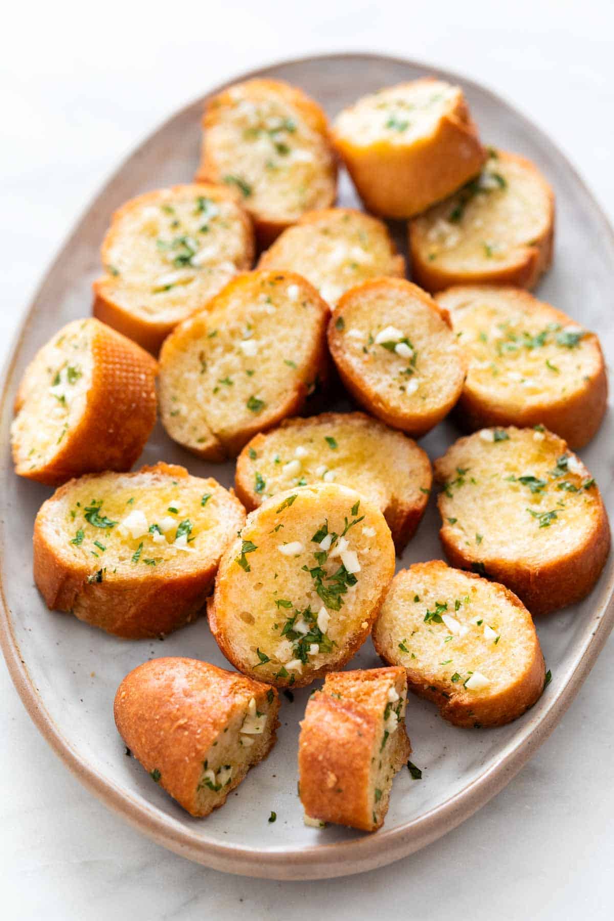 Vegan garlic bread slices on a serving dish.