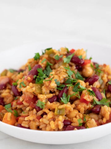 Picture of a dish with homemade vegan jambalaya topped with chopped parsley