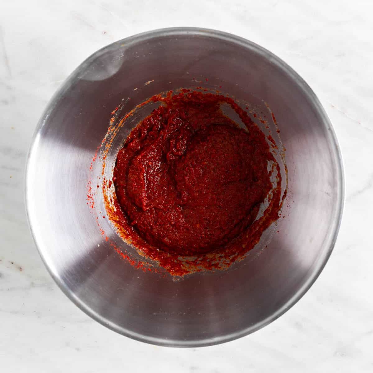 Kimchi paste in a bowl with gochugaru added.
