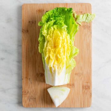 Quarter of cabbage on a cutting board with the core removed.