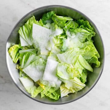 Chopped cabbage in a bowl with salt and water.