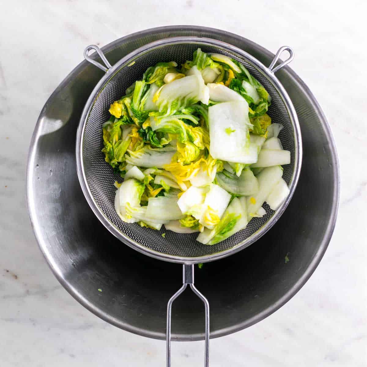 Cabbage in a strainer after rinsing to remove excess salt.