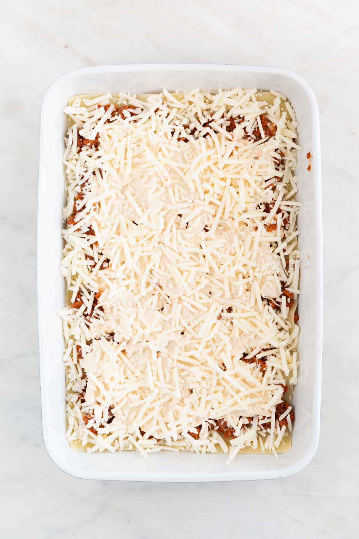 A casserole dish with a layer of vegan mozzarella.