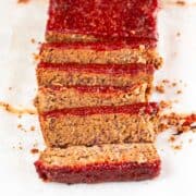 Sliced vegan meatloaf against a white backdrop.