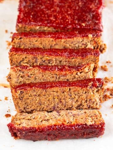 Sliced vegan meatloaf against a white backdrop.