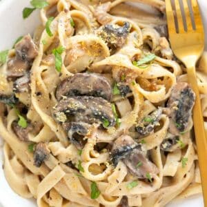Vegan mushroom pasta plate with a golden fork.