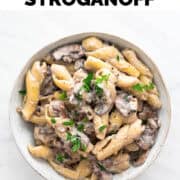 Vegan mushroom stroganoff in a dish with fresh parsley and black pepper.