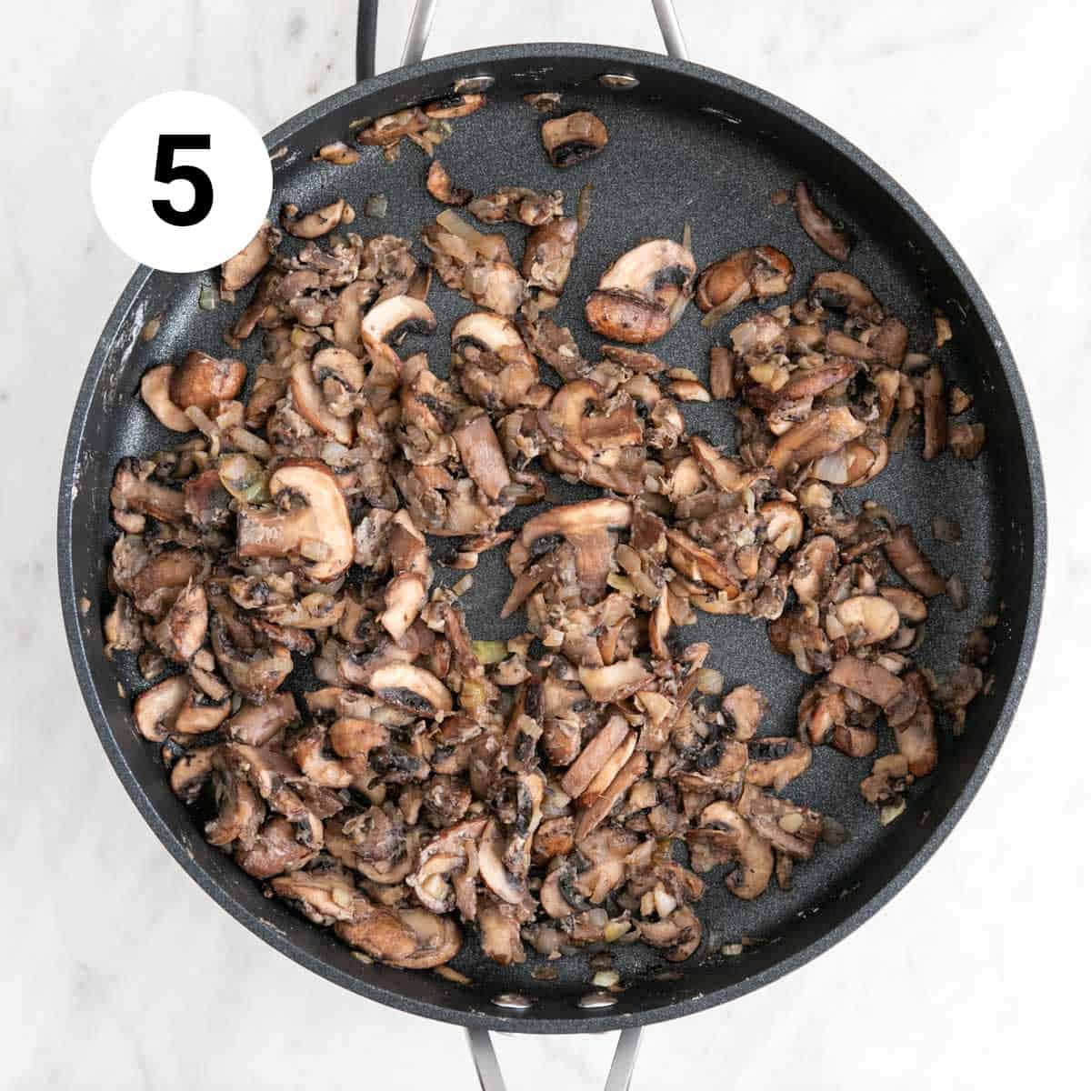 Onion, garlic, and mushrooms sautéed in a skillet with flour.