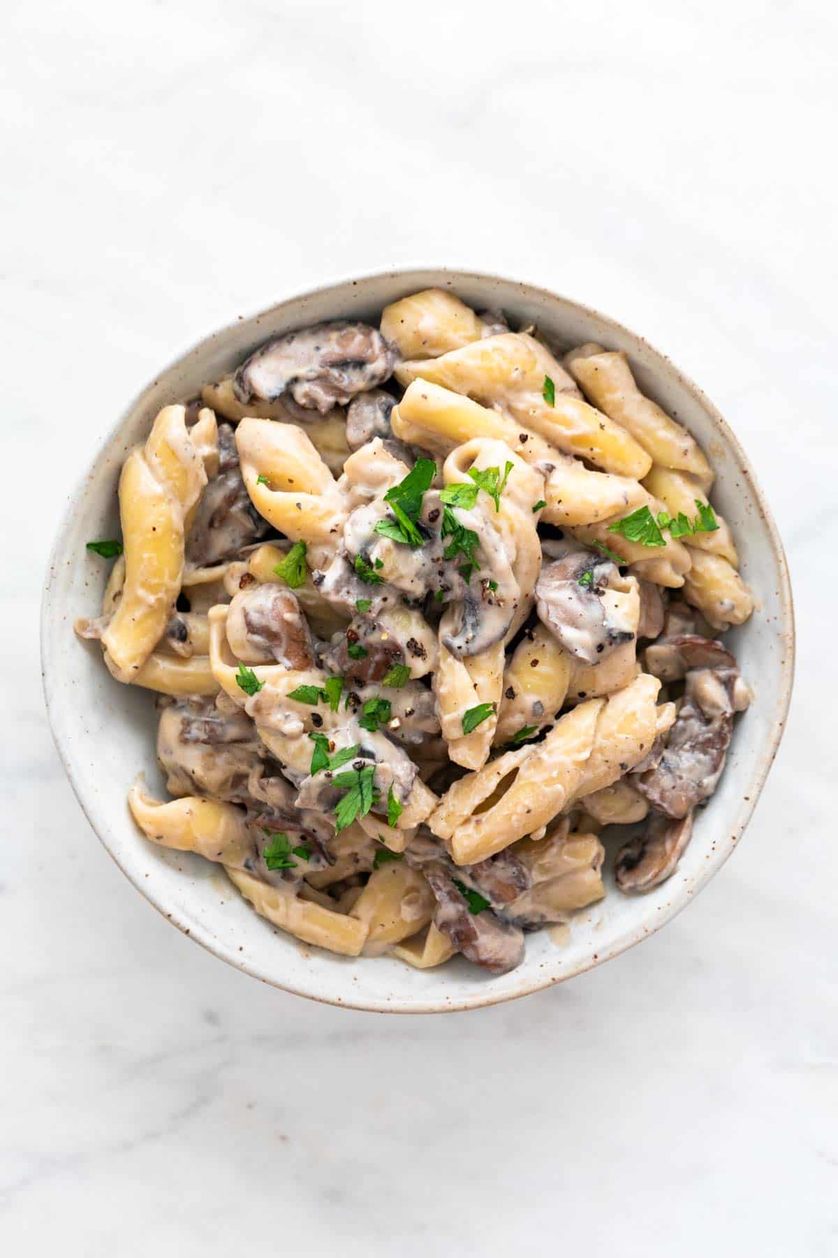 Vegan mushroom stroganoff in a dish with fresh parsley and black pepper.