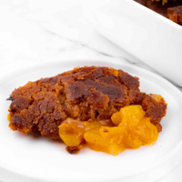 Square photo of some vegan peach cobbler on a plate
