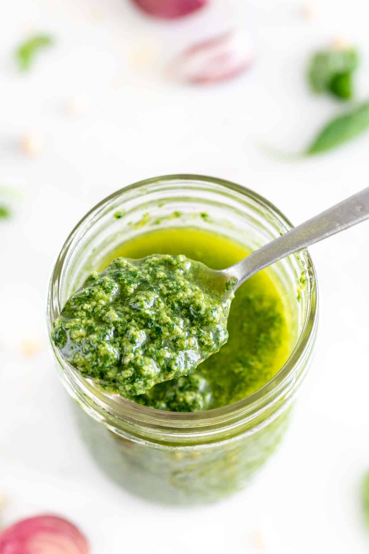 Vegan pesto jar with a spoon.