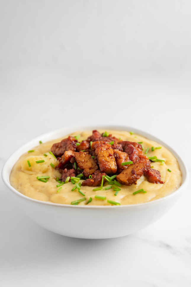 Photo of a bowl of vegan potato soup with tempeh bacon as a topping