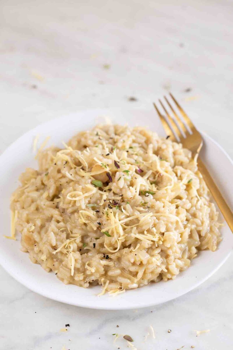 Photo of a dish of vegan risotto topped with herbs and vegan cheese