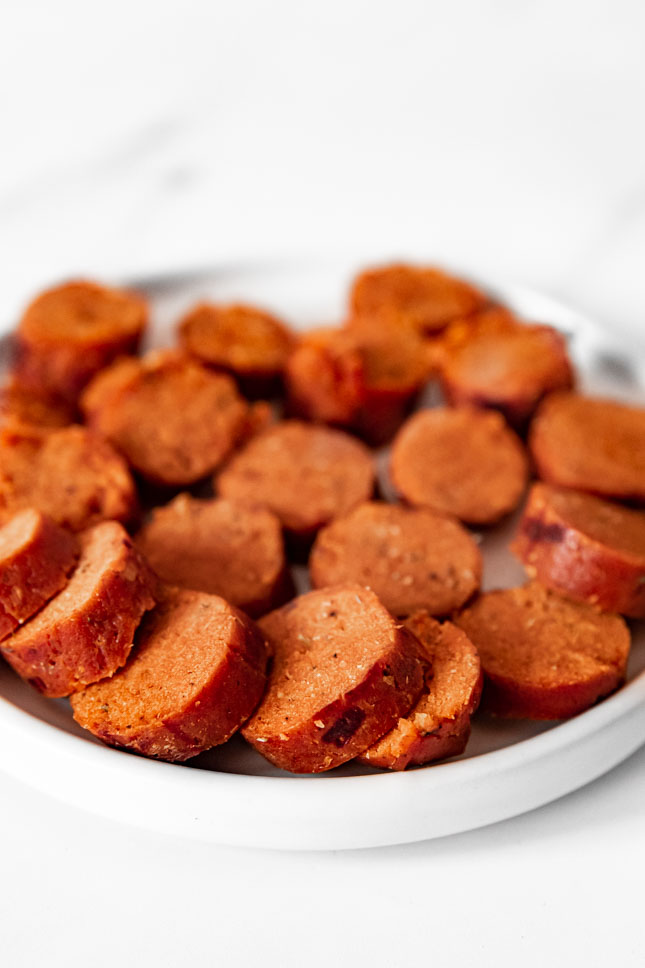 Photo of a plate with some vegan sausages cut in slices