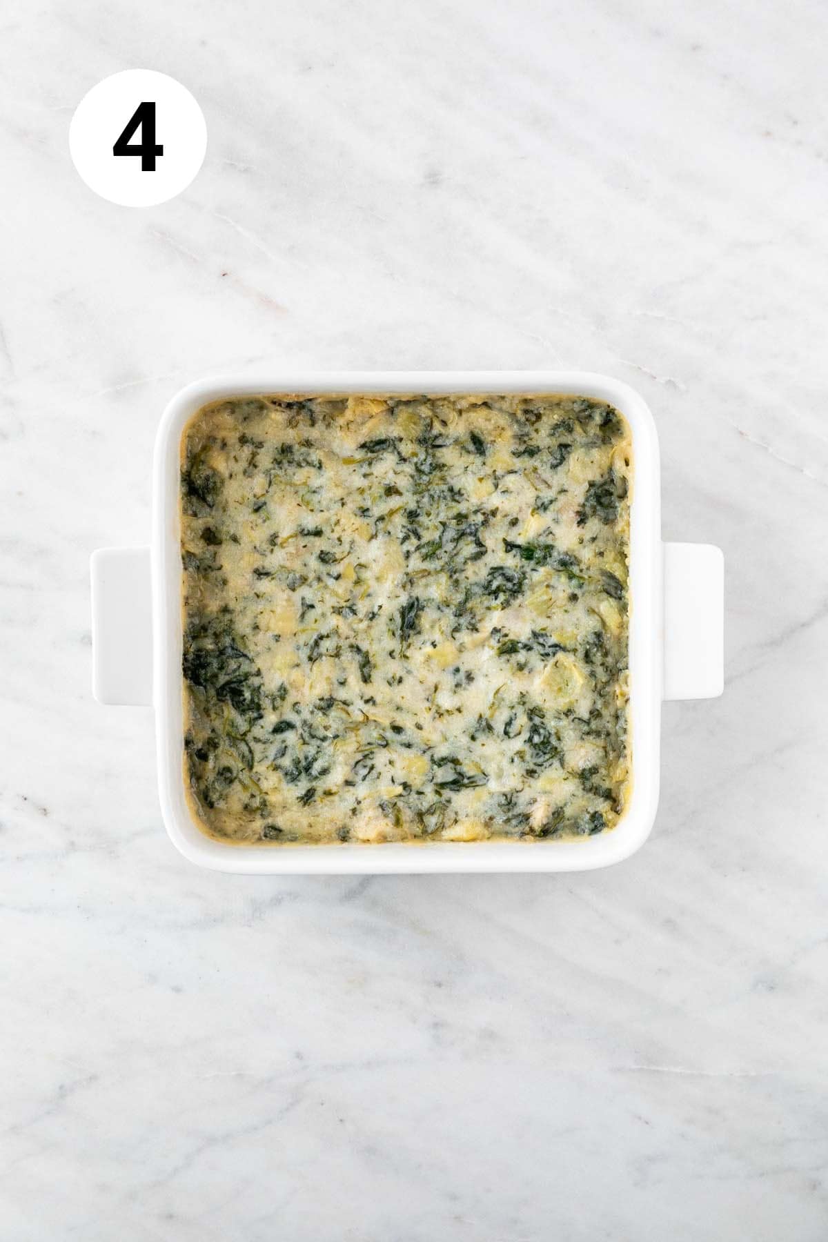 Baked vegan spinach artichoke dip in a baking dish.