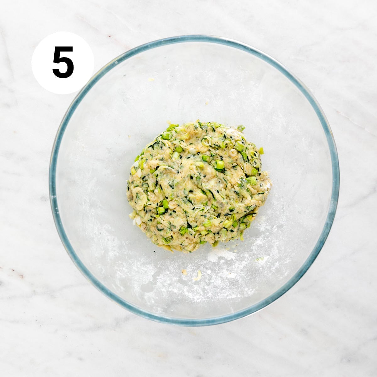 Vegan zucchini fritters batter in a bowl.