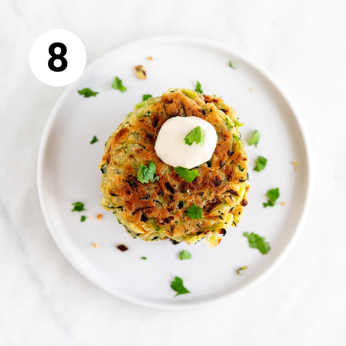 Vegan zucchini fritters served on a plate.