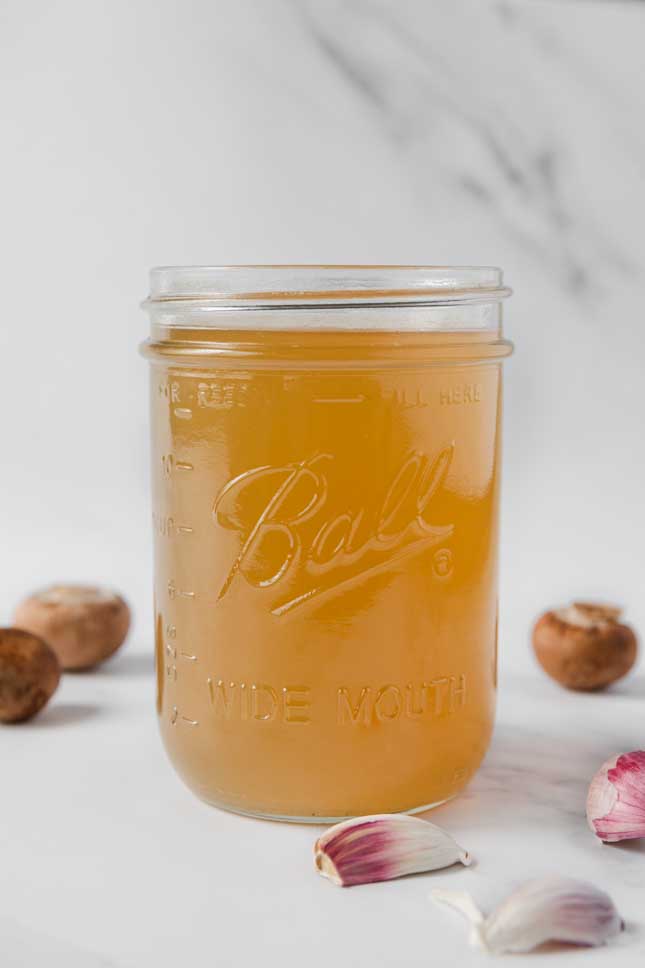 Side shot of a glass jar of vegetable stock