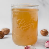 Square photo of a glass jar of vegetable stock