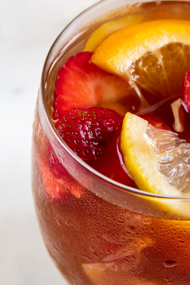 A close shot of a glass with white sangria and ice cubes